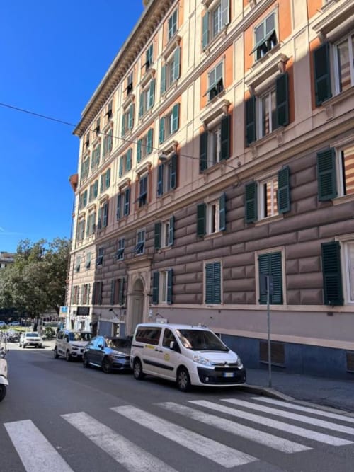 Edificio genovese storico con taxi parcheggiati, location Le Due Piazze B&B a Genova, Italia