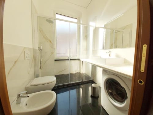 Bagno moderno dell'appartamento Le Due Piazze a Genova con wc, bidet, lavatrice, box doccia e finiture in marmo