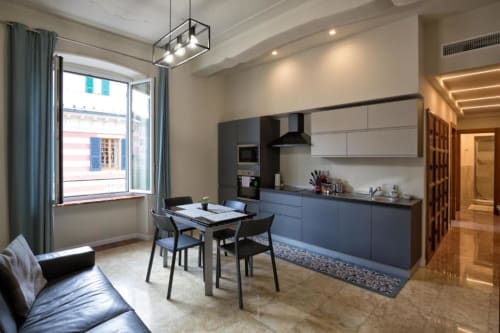 Cucina e zona pranzo di moderno appartamento con 2 camere a Genova, vista sulla città, arredamento nero elegante e contemporaneo
