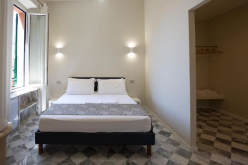 Camera moderna dell'appartamento Le Due Piazze a Genova con letto matrimoniale, vista sulla città e cabina armadio