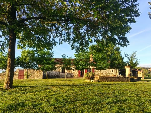 Maison en pierre du Domaine de Beau Site à Peyrat-de-Bellac, entourée d'une pelouse soignée et d'arbres matures