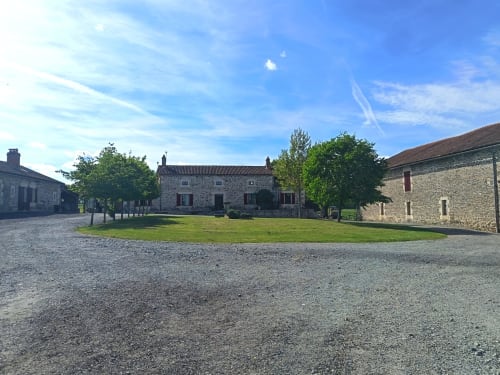 Cour pavée au Domaine de Beau Site, gîte rural français près de Peyrat-de-Bellac avec bâtisses rustiques et jardins soignés