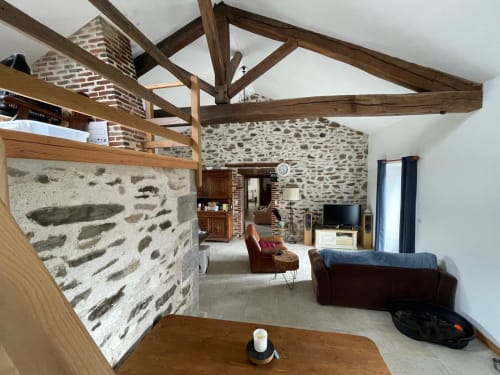 Spacieux salon de cottage aux poutres en bois apparentes, murs en pierre et mobilier contemporain du Domaine de Beau Site