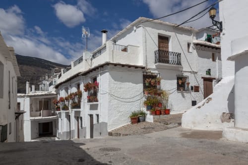 White-washed building with terracotta flower pots at Hotel Mulhacén Trevélez in Granada, Spain