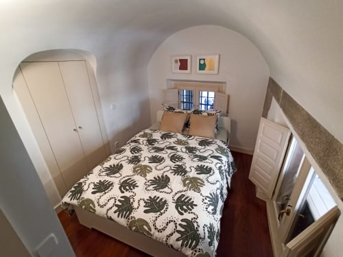 Cozy bedroom with patterned bedding, wardrobe storage, and window at Charming view Plaza Mayor apartment in Madrid