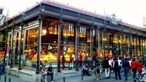 Historic Plaza Mayor market hall with elegant architecture, shopfronts, and crowds in Madrid city center