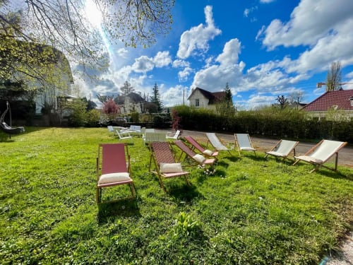 Jardin ensoleillé avec chaises longues et bancs à l'Hôtel d'Angleterre de Vittel, France