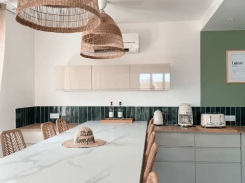 Cuisine moderne à la Villa Rompsay ARLOÉ à La Rochelle : plan de travail en marbre, luminaires suspendus tissés et crédence en carreaux verts