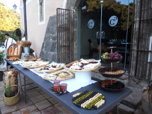 Buffet al aire libre en Can Carol Hotel Restaurant de Capellades con panes, quesos, embutidos, aceitunas y uvas frescas