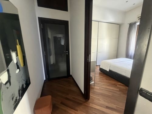 Camera moderna di ROOMITO APARTMENTS Napoli con pavimenti in legno, letto, guardaroba e bagno en-suite accessibile