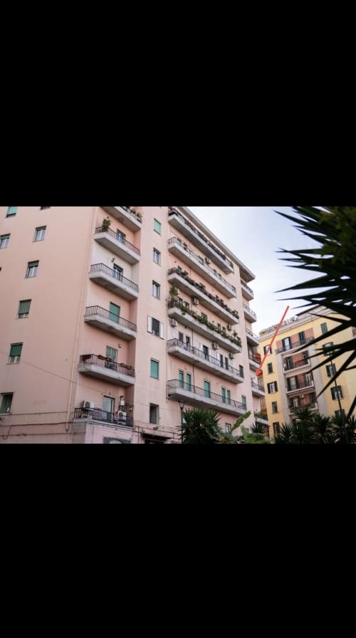 Edifici residenziali rosa e gialli con balconate a Napoli, vista della città da ROOMITO APARTMENTS