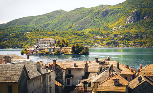 MiSaNi Apartments affacciato sul Lago di Como con tetti in terracotta, montagne alpine e villa storica sul lungolago in Italia