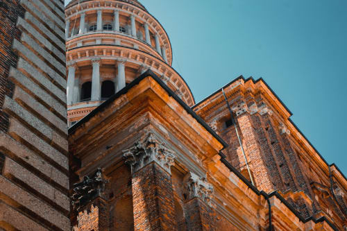 Torre storica in mattoni con cupola ornamentale sotto cielo azzurro, MiSaNi Apartments, Italia