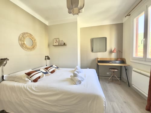 Chambre lumineuse de l'appartement L'Ajax à Alata avec lit queen-size, bureau de travail, vue mer et équipements modernes