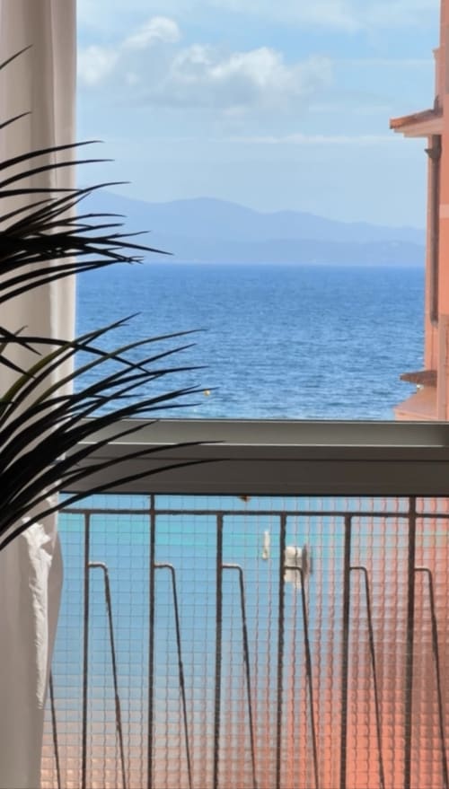 Vue depuis le balcon de l'appartement L'Ajax à Alata, France avec vues sur la mer, palmiers et montagnes de la Méditerranée