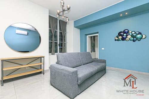 Appartamento moderno a ML White House nel centro storico di Genova con divano grigio, pareti turchesi e vista sulla città