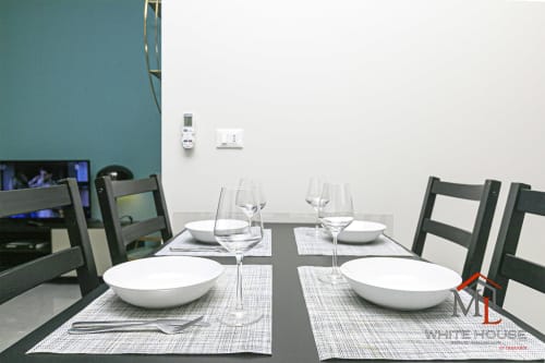 Tavolo da pranzo apparecchiato per due ospiti presso l'appartamento ML White House Centro Storico a Genova, con posate e calici di vino