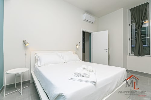 Camera da letto moderna presso ML White House a Genova con letto matrimoniale, biancheria bianca, aria condizionata e vista sulla città