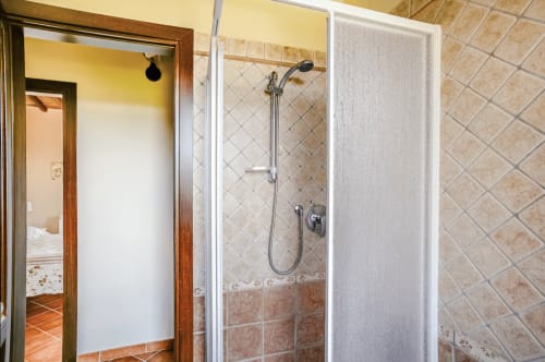 Bathroom shower with glass enclosure and beige tile at Casa Rossi Roma hotel