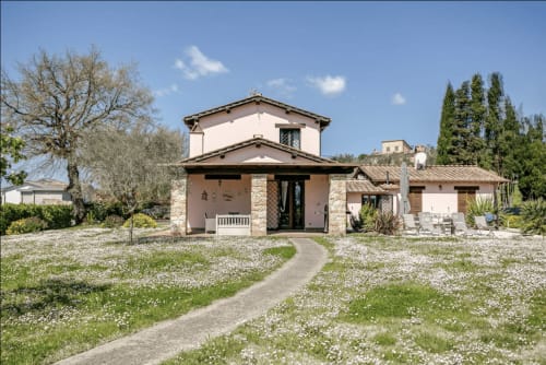 Casa Rossi Roma: Contemporary villa with stone façade, arched entrance, and manicured gardens with white flowers near Rome