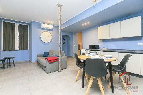 Appartamento moderno ML White House Centro Storico A4 a Genova: spazi contemporanei con cucina, tavolo da pranzo, divano grigio e vista sulla città