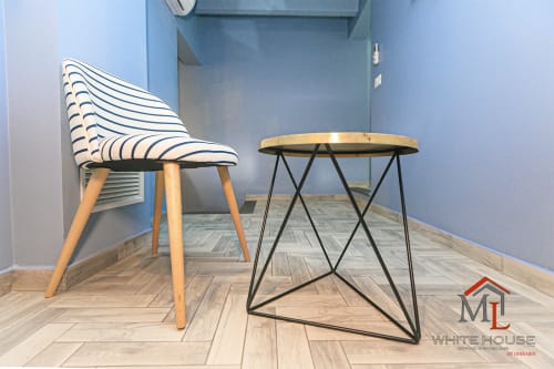 Zona living moderna a Genova con sedia rigata, tavolino geometrico e pavimento a spina di pesce in ML White House
