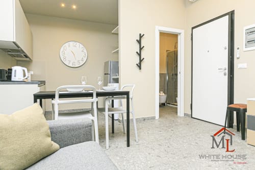 Cucina moderna e zona living in ML White House a Genova Centro Storico con tavolo da pranzo e divano