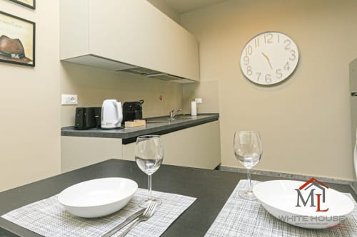 Cucina moderna e zona pranzo in Centro Storico Apartments, Genova con angolo cottura attrezzato e tavolo apparecchiato
