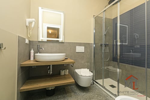 Bagno moderno della ML White House Genova con lavabo vessel, doccia a pioggia e specchio riscaldato