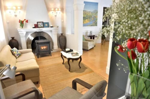 Acogedora sala de estar del Hotel Can Carol con chimenea, asientos y tulipanes rojos en Capellades