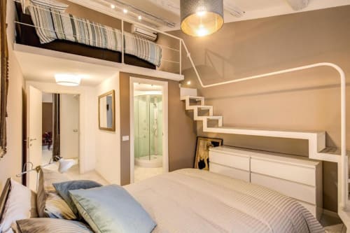Moderno monolocale a Roma con letto a soppalco, cucina, bagno e doccia, dal design contemporaneo e illuminazione calda