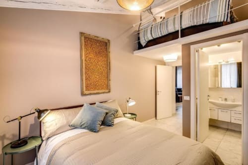 Camera moderna nell'appartamento The Great Pop presso Downtown Srl Roma, con letto dai cuscini blu, opere d'arte, scaffali e