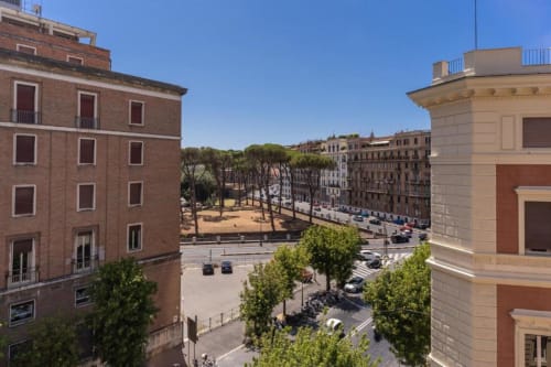 Splendida vista sulla piazza soleggiata del centro di Roma dall'appartamento The Great Green, con edifici storici e alberi