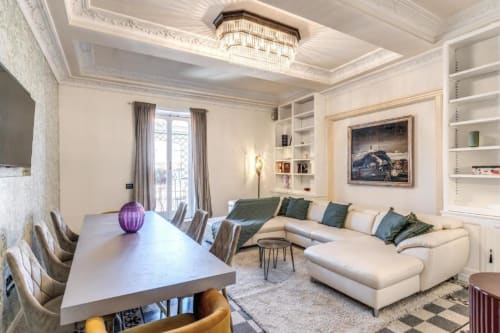 Elegante appartamento open-plan a Roma con arredi moderni, divano componibile color crema, tavolo da pranzo con accento viola, ripostigli in