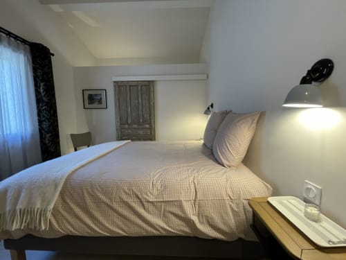 Modernes Schlafzimmer im SARL MARIEMEO Hotel in Gordes mit Queensize-Bett, schwarzer Stehleuchte und rustikalem Holzschrank