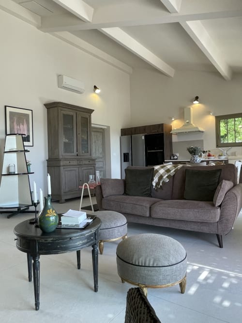 Modernes offenes Wohnzimmer in Gordes mit grauem Sofa, schwarzem Couchtisch und sichtbaren Balken