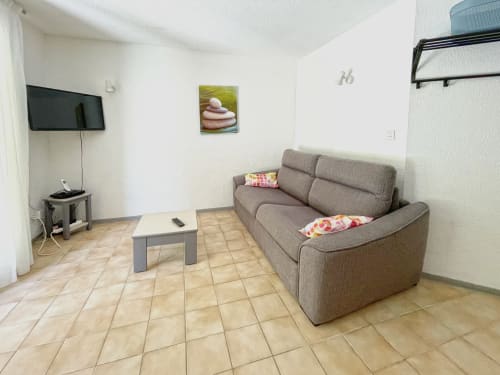 Séjour de l'appartement Vallon des Sources à l'hôtel LOCADIGNE à Digne-les-Bains avec canapé gris, TV et vue montagne