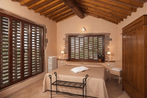 Appartamento Lischeto a Villa Olena a Reggello con travi in legno, finestre con persiane e vista sul giardino