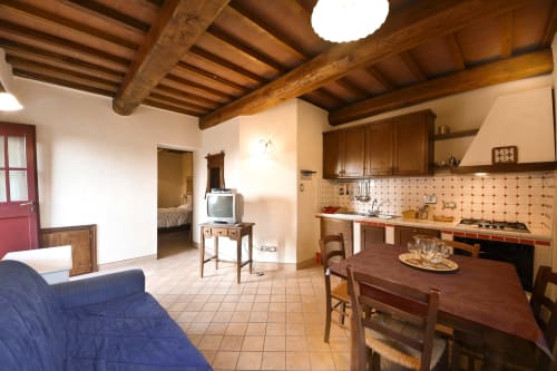 L'appartamento Roncaticcio a Villa Olena a Reggello con travi in legno a vista, tavolo da pranzo, angolo cottura e zona living