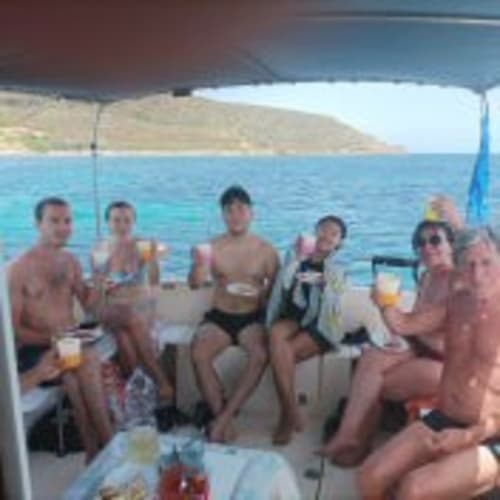 Gruppo che gusta drink durante escursione in barca con Pescaturismo Lia a Stintino, mare turchese e costa