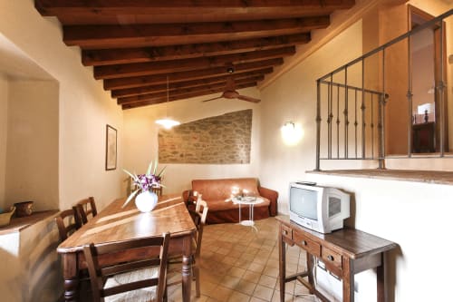 Sala Morgone a Villa Olena, Reggello - rustica zona living con travi in legno, tavolo da pranzo, divano letto e TV