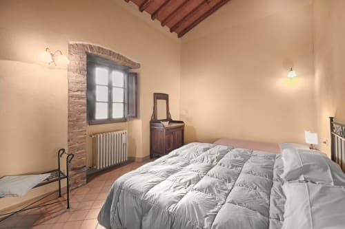 Spaziosa camera da letto a Villa Olena a Reggello con letto queen, vista giardino, travi di legno e comfort moderni
