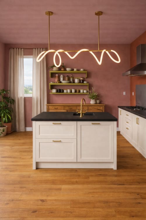 Cuisine moderne aux murs terracotta, îlot blanc, plan de travail noir et suspensions néon dorées à La Maison 1903