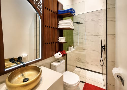 Salle de bain moderne à la Villa Merida Boutique Hotel avec lavabo doré, douche à l'italienne et rangements organisés pour les serviettes.