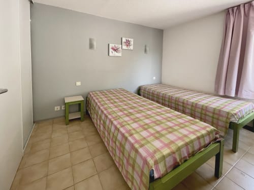 Chambre twin avec lits verts et literie à carreaux roses à LOCADIGNE Vallon des Sources, Digne-les-Bains