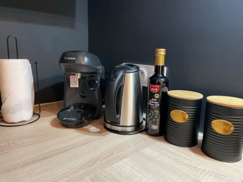 Station à café avec machine Bosch, bouilloire, bouteille de vin et boîtes de rangement à l'appartement Les Logis d'Emma