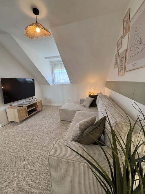Appartement moderne sous les toits aux Logis d'Emma avec salon confortable, télévision écran plat et lumière naturelle