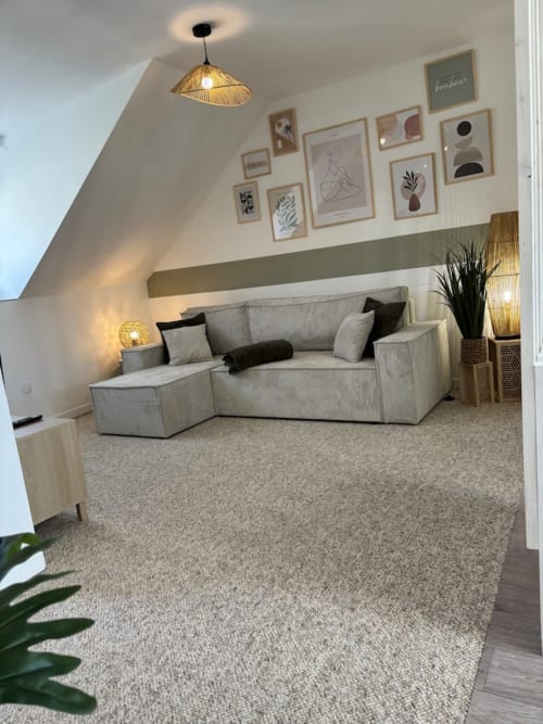 L'appartement Col'Vert aux Logis d'Emma avec canapé gris moderne, mur de galerie et ambiance chaleureuse avec vue montagne