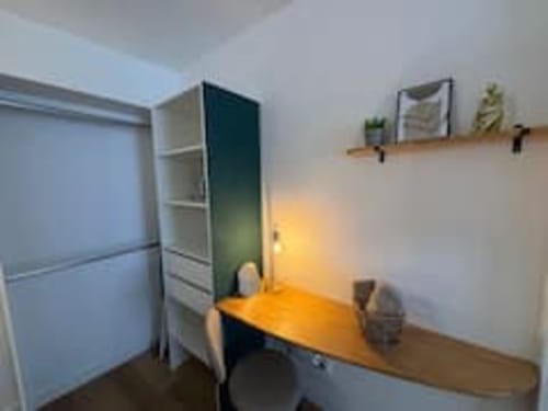 L'espace bureau de l'appartement Midori aux Logis d'Emma avec bureau en bois, chaise, étagères et décoration murale