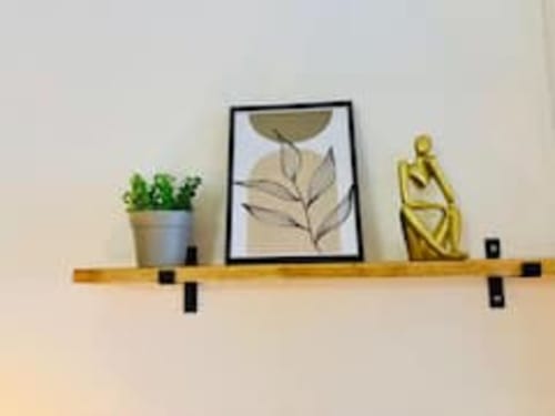 Étagère en bois de l'appartement Midori aux Logis d'Emma avec plante en pot, art botanique encadré et sculpture dorée